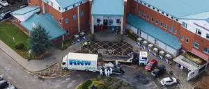 Kriminalbeamte der Polizei stehen in der Nähe der Überreste eines Taxis, das am 17. November 2021in Liverpool explodierte.