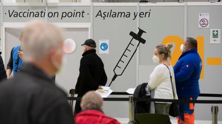 Menschen warten im Impfzentrum unter dem Messeturm auf ihre Impfung.