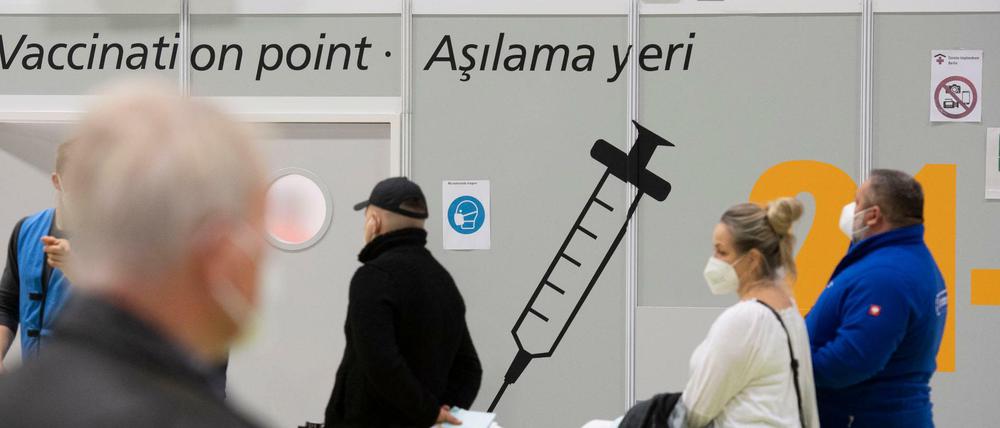 Menschen warten im Impfzentrum unter dem Messeturm auf ihre Impfung.