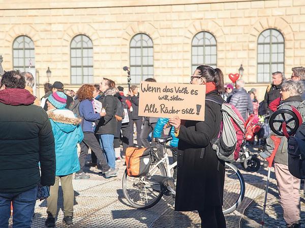 Eine Demonstrantin trägt ein Schild mit der Aufschrift Wenn das Volk es will, stehen alle Räder still.