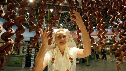 Dafür lieben die Menschen die Grüne Woche: Susanne Roch aus Golßen zeigt in der Halle ihres Bundeslandes Brandenburg frische Würste. Das war vor zwei Jahren. Letztes Jahr gab es die Messe nur online. 