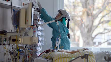 Ein Intensivpflegerin versorgt eine Corona-Patientin, die an einen ECMO-Gerät angeschlossen ist.