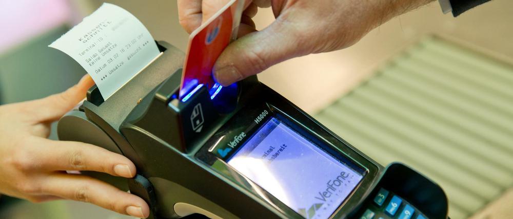 Ein Kunde zahlt in einem Supermarkt mit einer EC-Karte an der Kasse.