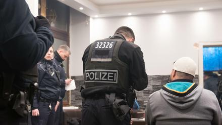  Beamte der Berliner Polizei, Zoll und Ordnungsamt durchsuchen ein Café. 