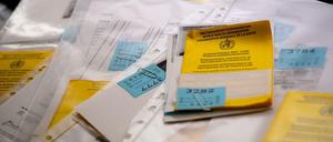 Zahlreiche Impfpässe liegen in einer Apotheke in einem Büro auf einem Tisch.