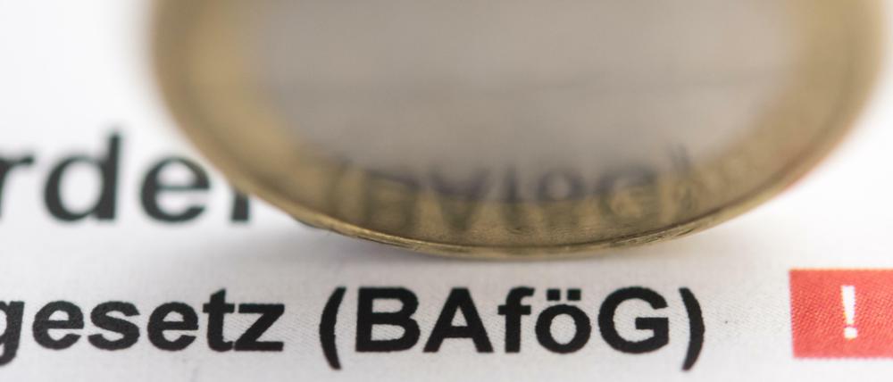 Auf einem Ausdruck des Bafög-Gesetzes steht eine Euro-Münze.