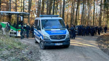 Polizisten und Einsatzfahrzeuge stehen in einem Waldstück. Ein Waldarbeiter hatte dort einen Knochen gefunden.