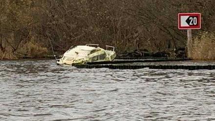 Ein Bootswrack liegt am Havelufer in Berlin-Kladow im Wasser.