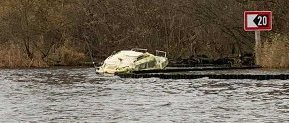 Ein Bootswrack liegt am Havelufer in Berlin-Kladow im Wasser.