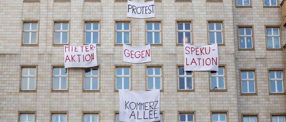 Plakate gegen den Verkauf von Mietwohnungen an die Deutsche Wohnen SE hängen an einer Gebäudefassade in der Karl-Marx-Allee. Berlin ist ein Magnet. Aus allen Teilen der Republik ziehen Menschen dorthin - mit Nebenwirkungen: Der Wohnungsmarkt ist vielerorts leer gefegt.