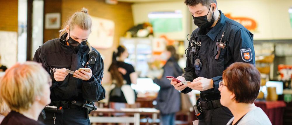 Wichtiger als Verkehrskontrollen. Polizisten prüfen in einem Lokal in Hannover, ob die Gäste einen gültigen Impfnachweis haben