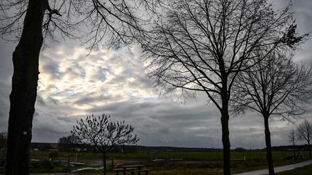Nur ein kleine Wolkenlücke zeigt sich zwischen grauen Regenwolken über einem Feld im brandenburgischen Zauchwitz. Das kalte und regnerische Wetter soll in den nächsten Tagen anhalten, teilweise ist Schnee vorhergesagt. Foto: Jens Kalaene/dpa