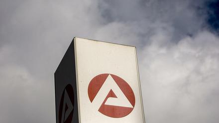Wolken ziehen über ein Schild der Bundesagentur für Arbeit. 