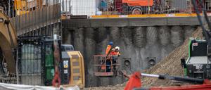 Bauarbeiter betrachten einen Tag nach der Explosion einer Fliegerbombe den Krater auf der Baustelle.