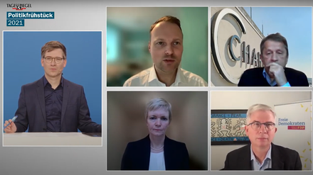Auf einem Bildschirm sind fünf Personen in einer Videokonferenz zu sehen.