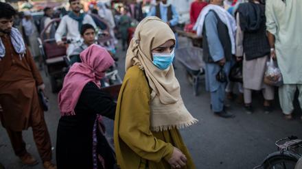 Afghanische Frauen gehen über einen Einkaufsmarkt in Kundus. 