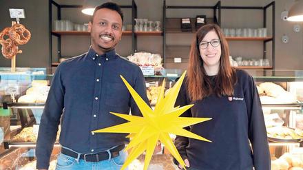 Kleine Freude, große Freude. Hamzah Ali, ehrenamtlicher Seniorenhelfer, und Susanne Schattschneider vom interkulturellen Besuchsdienst „Türöffner“ von Malteser und Caritas, in der Café-Bäckerei am Theodor-Loos-Weg. Die 96-jährige Elli Rothkopf, die der junge Mann aus Rudow besucht, arbeitete früher auch in einer Bäckerei. Zum Treffen konnte sie leider nicht kommen, sie lag im Krankenhaus.