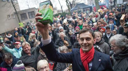 Martin Hikel (SPD, M), Bezirksbürgermeister von Berlin-Neukölln, hält beim ersten Hilfe-Flashmob «Kaffee gegen Kälte» zusammen mit zahlreichen anderen Spendern ein Paket Kaffee in die Höhe. 
