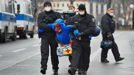 Polizisten tragen einen Demonstranten in Dresden weg. Dort war es zu Protesten vor dem Sächsischen Landtag gekommen.