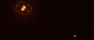 Der Doppelstern b Centauri (links oben) ist sechs mal so massiv wie die Sonne und so heiß, dass es nach gängiger Theorie zur Planetenentstehung eigentlich gar keinen Planeten in seiner Nähe (rechts unten) geben dürfte.