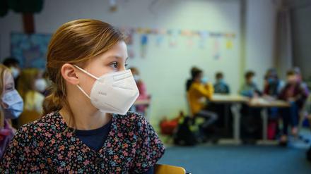 Eine Schülerin einer 4. Klasse sitzt im Unterricht an der Grundschule Russee in Kiel mit einer FFP-2-Maske an ihrem Platz.