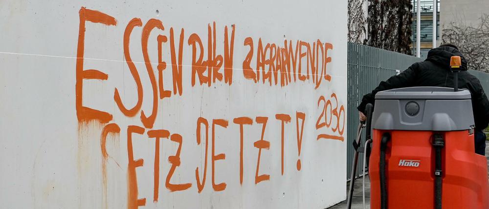Reinigungskräfte entfernen am Bundeskanzleramt den Schriftzug "Essen Retten Agrarwende Gesetz jetzt! 2030".