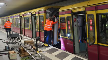 Bahn-Arbeiter an dem entgleisten Waggon im Bahnhof Friedrichstraße.