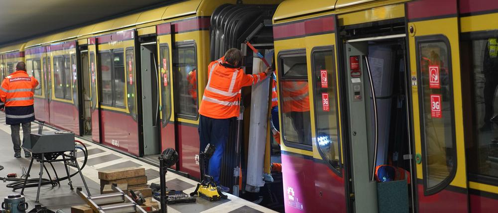 Bahn-Arbeiter an dem entgleisten Waggon im Bahnhof Friedrichstraße.
