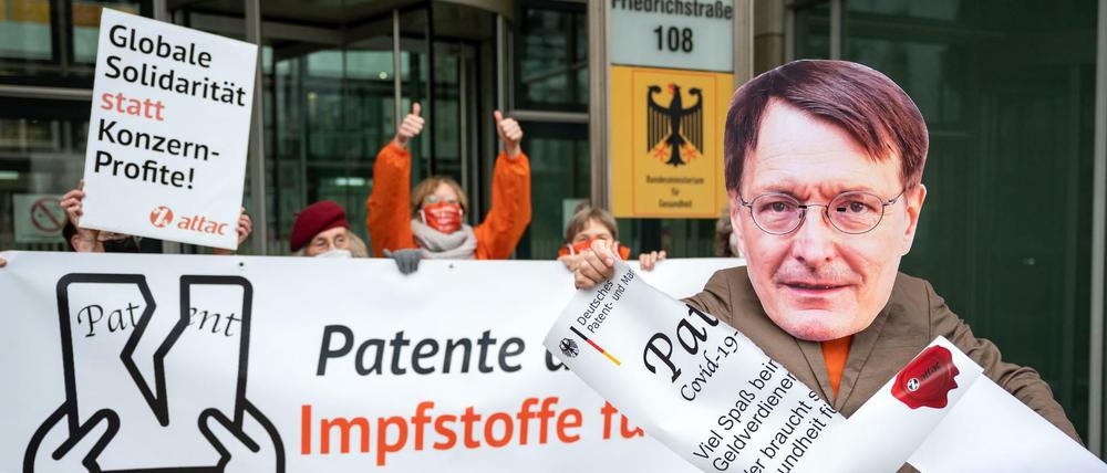 Aktivisten der globalisierungskritischen Organisation Attac demonstrieren vor dem Bundesministerium. Ein Demonstrant trägt eine Maske mit einem Foto von Bundesgesundheitsminister Lauterbach. Attac fordert die Aussetzung der Patente für Covid-Impfstoffe.