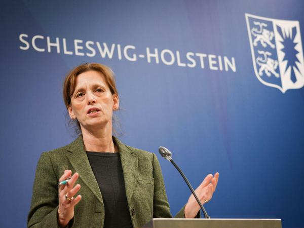 Karin Prien steht auf einem Podium und spricht gestikulierend in ein Mikrofon.