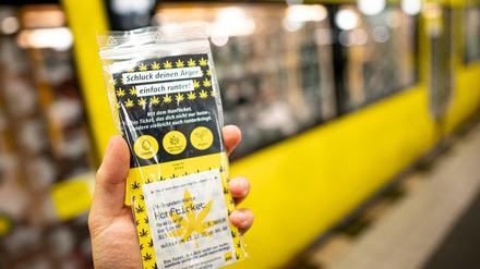 Eine Person hält in einer U-Bahn Station das Hanfticket der BVG in der Hand. 