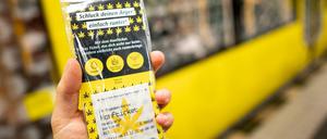 Eine Person hält in einer U-Bahn Station das Hanfticket der BVG in der Hand.