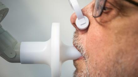 Ein Patient in einer Klinik, in der Long-Covid-Fälle behandelt werden, bei der Überprüfung seiner Lungenfunktion.