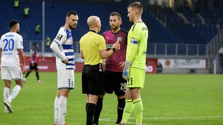 Schiedsrichter Nicolas Winter erklärt den Spielern, warum das Spiel nicht fortgesetzt werden kann.