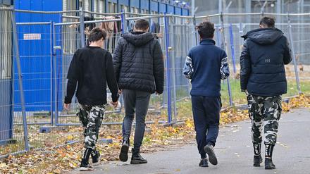 Migranten gehen über das Gelände der Erstaufnahmeeinrichtung in Eisenhüttenstadt.