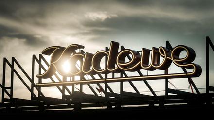 Historischer Schriftzug des KaDeWe am Wittenbergplatz in Berlin-Schöneberg unter bewölktem, aber sonnigem Himmel.