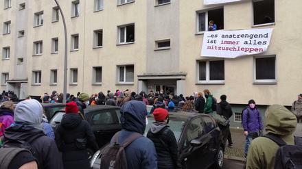 Unterstützter sammeln sich vor dem Haus in Mitte. Aus den Fenstern hängen Transparente. 