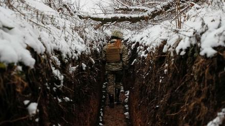 Eine ukrainische Soldatin läuft durch einen Graben nahe der russischen Grenze.