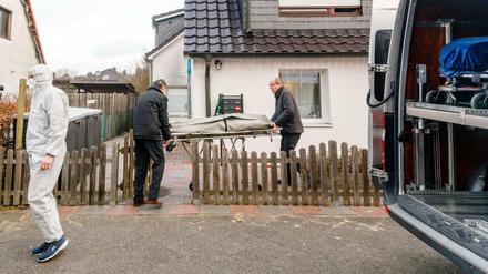 Zwei Bestatter bringen eine Trage mit einem Leichnam aus einem Haus. In dem Wohnhaus in Glinde bei Hamburg sind drei Tote gefunden worden. 