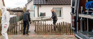 Zwei Bestatter bringen eine Trage mit einem Leichnam aus einem Haus. In dem Wohnhaus in Glinde bei Hamburg sind drei Tote gefunden worden.