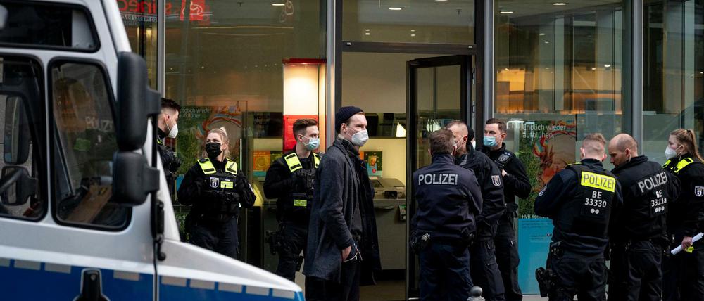 Polizisten stehen vor der Hypovereinsbank in der Friedrichstraße. Bankräuber haben die Bank überfallen und mehrere Menschen mit Reizgas verletzt.