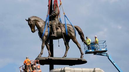 Arbeiter entfernen eine Bronzefigur des Südstaaten-Generals Robert Edward Lee auf der Monument Avenue.