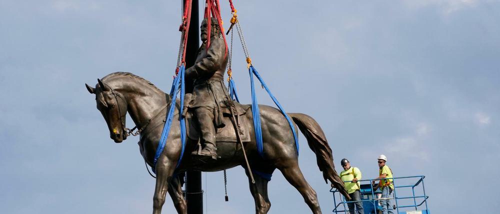 Arbeiter entfernen eine Bronzefigur des Südstaaten-Generals Robert Edward Lee auf der Monument Avenue.