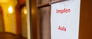 Ein Hinweisschild mit der Aufschrift: "Impfen Aula" hängt an einer Tür in einer Schule.