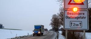 Ein Straßenschild warnt mit einer Blinkleuchte vor Glatteis. Für den Vormittag wurde im Süden vor Eisregen gewarnt.