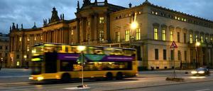 Ein Bus fährt vorbei an der Alten Bibliothek (Kommode) am Bebelplatz in der Straße Unter den Linden im Berliner Bezirk Mitte. 