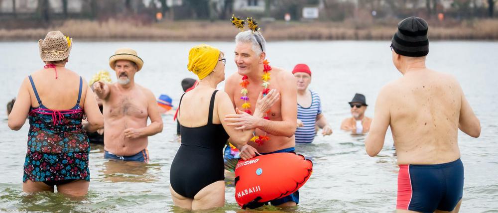Winterschwimmer des Vereins „Berliner Seehunde“ stehen beim Neujahrsschwimmen im Orankesee.