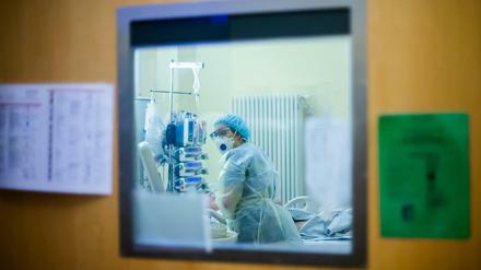 Eine Assistenzärztin betreut auf einer Intensivstation einen Covid-19-Patienten.