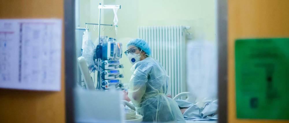 Eine Assistenzärztin betreut auf einer Intensivstation einen Covid-19-Patienten.