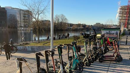 E-Roller, die von der Organisation Spree:publik aus der Spree gefischt wurden, stehen in einer Reihe am Ufer.